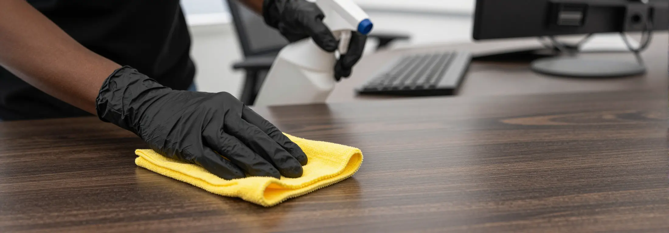 Disinfecting an office desk with eco spray and microfibre